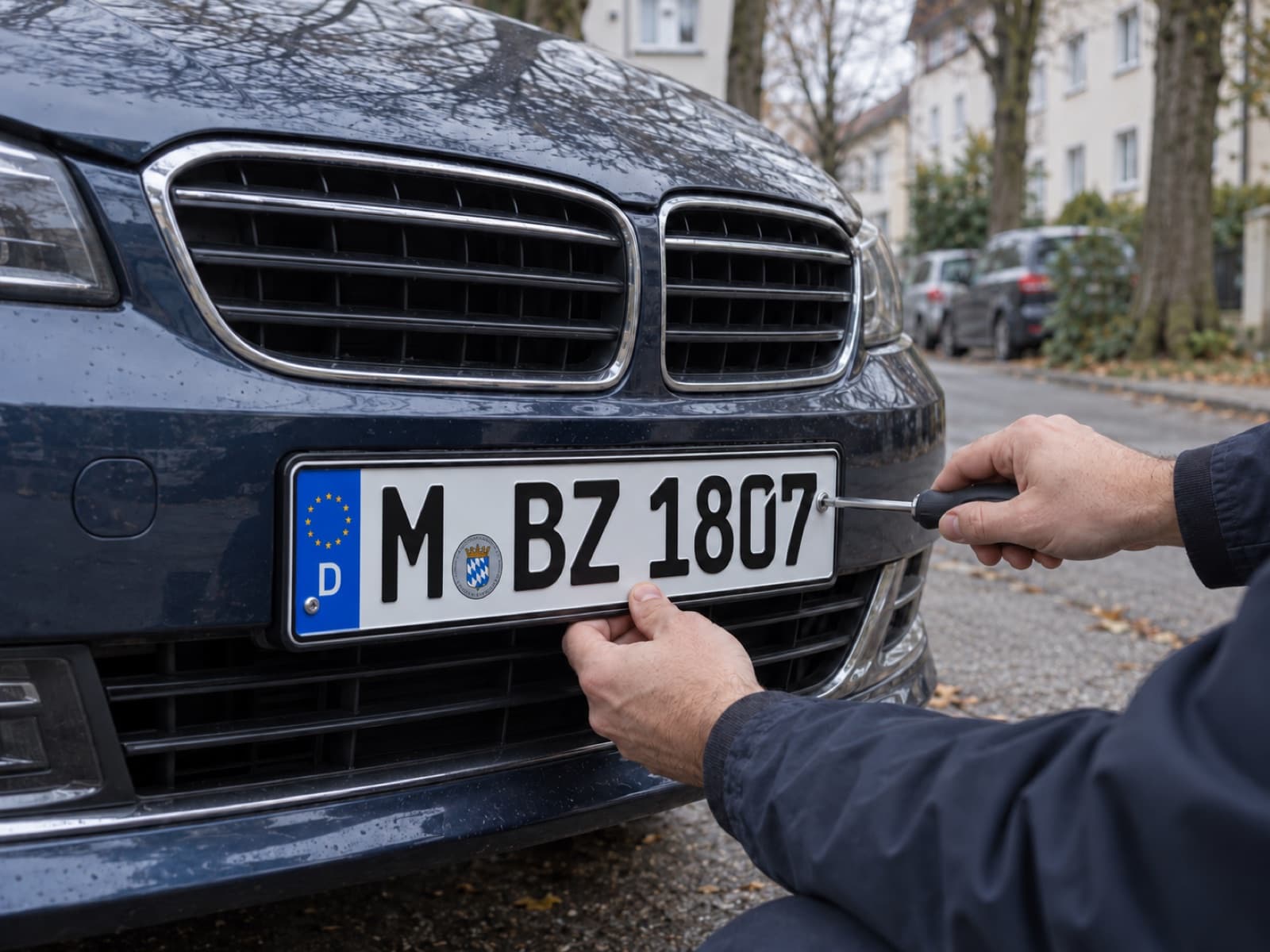 Neues Kennzeichen wird an ein Auto geschraubt